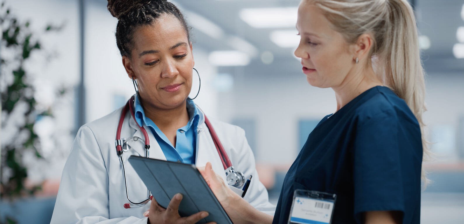 Two women health workers talking to each other and looking at paperwork