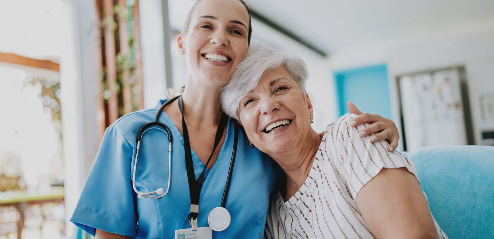 Smiling health worker with arm around smiling patient