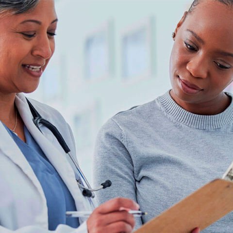 Female doctor talking to patient looking at paperwork together
