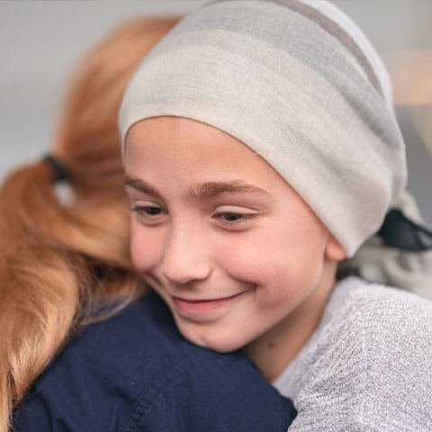 Girl with headscarf smiling and hugging healthcare worker